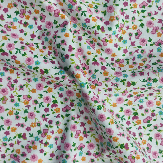 Tejido con estampado de flores azules en fondo diferentes colores.